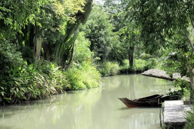 Küçük tekne yaz aylarında ağaçlarıyla çevrili kanalı ile gündüz. 