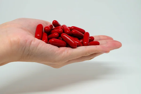 Capsule di vitamina rossa sul palmo della mano — Foto Stock