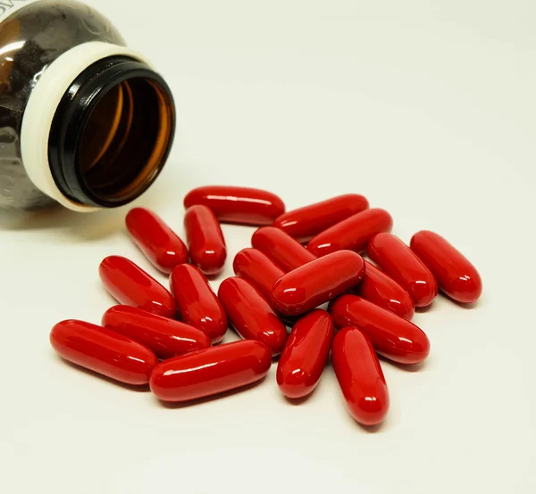 Capsule rosse di vitamina dal flacone — Foto Stock