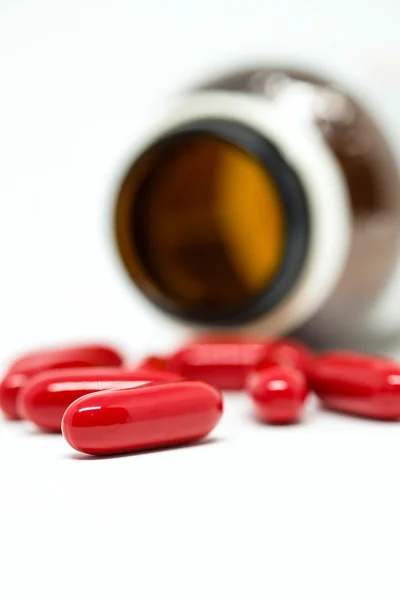 Czerwony dodatku tabletki i butelki — Zdjęcie stockowe