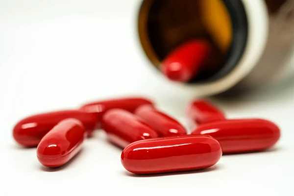 Red capsules spilled out from bottle