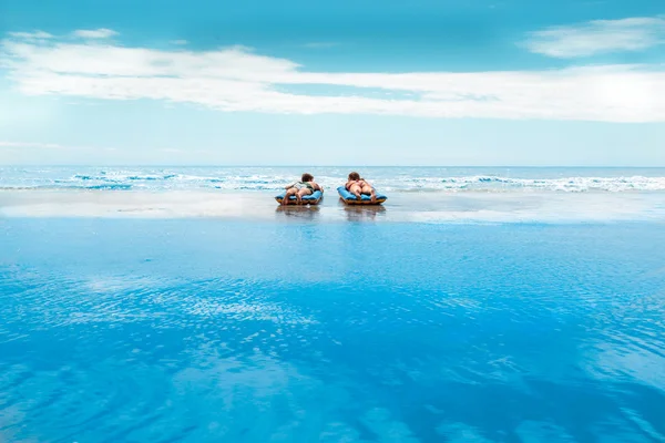 A young and beautiful newly-married couple enjoying on an inflat — Stock Photo, Image