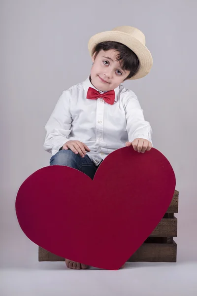 Usměvavý chlapec s červeným srdcem — Stock fotografie