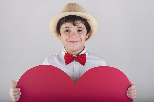 Niño sonriente con un corazón rojo — Foto de Stock
