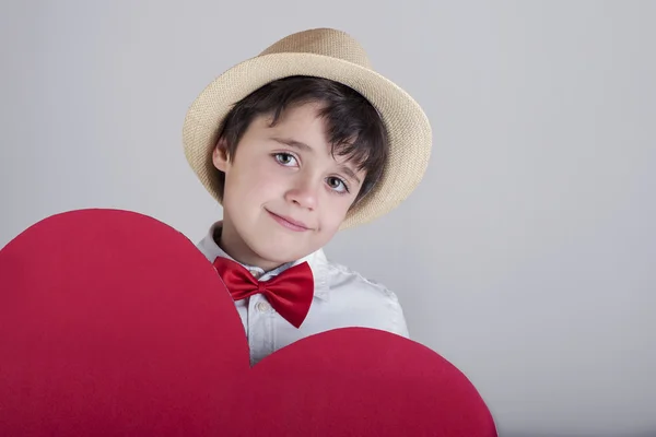 Niño sonriente con un corazón rojo — Foto de Stock