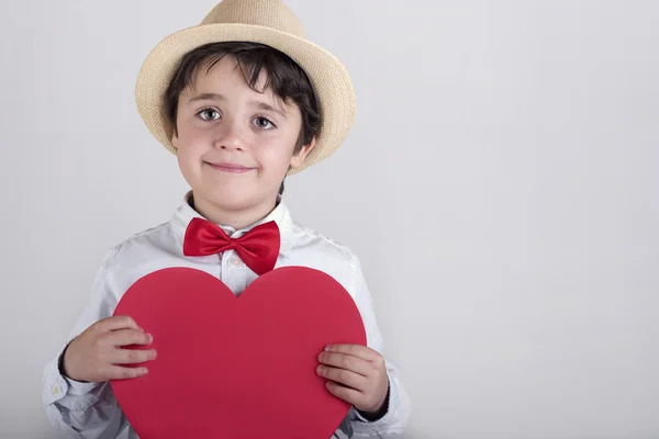 Niño sonriente con un corazón rojo —  Fotos de Stock