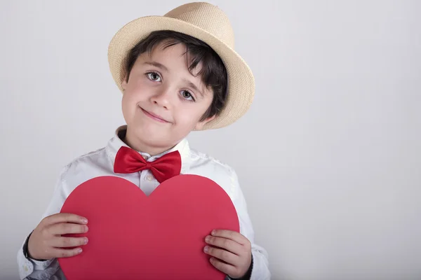 Niño sonriente con un corazón rojo —  Fotos de Stock