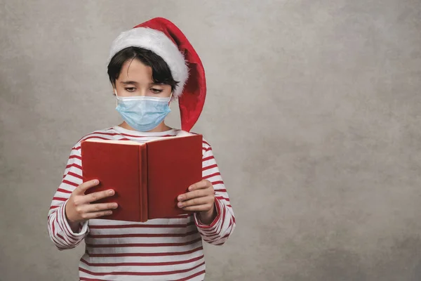 Веселого Різдва Дитина Медичною Маскою Вдягаючи Різдвяний Санта Клаус Капелюх — стокове фото