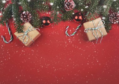 Mutlu Noeller. Noel konsepti. Noel ağacı dalları ve gri arka planda kar taneleri olan Noel hediyeleri. 