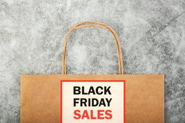 Kara Cuma. Üzerinde gri zemin yazılı kahverengi alışveriş çantası. Zıplama kavramı.