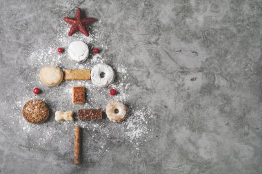 Noel süslemeli fındıklar, mantekadolar ve polvoronlar. İspanya 'da tipik Noel tatlısı çeşitleri gri arka planda bir Noel ağacı şeklinde.
