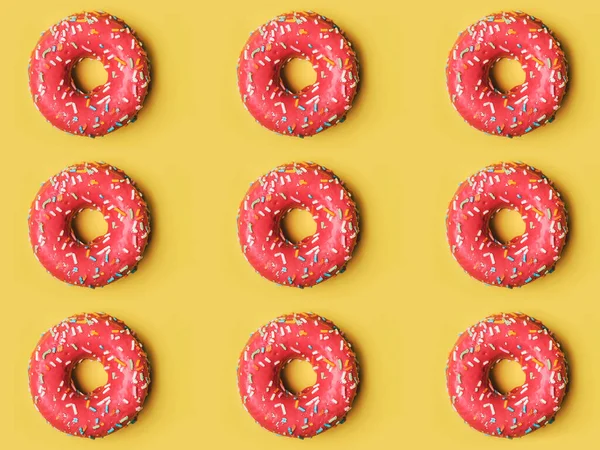 Rosquinhas Rosadas Com Cobertura Fundo Amarelo — Fotografia de Stock