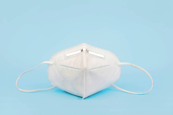 surgical mask FP2,KN95 mask as covid-19 coronavirus protection isolated on blue background.Covid 19 concept