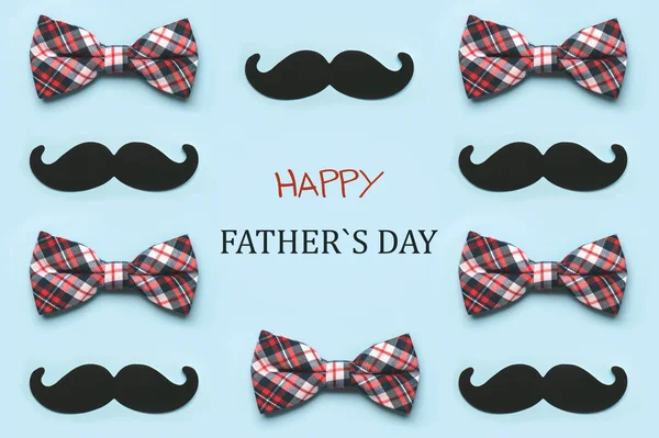 Happy Father\'s Day.Geometric pattern made with bow tie and false mustache on blue background