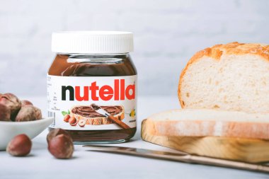 Masada fındık ve ekmek dilimleri olan fındık kavanozu.