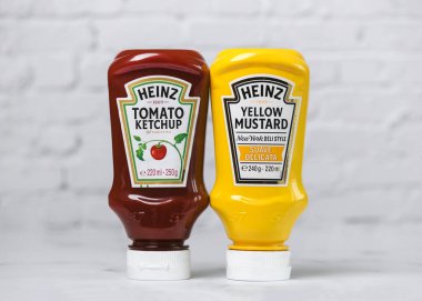 Heinz Ketçap şişesi ve beyaz bir masada bir şişe Heinz Sarı Hardal.