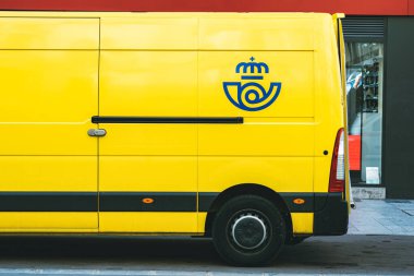 İspanyol posta şirketi Correos 'un sarı teslimat minibüsü. İspanya' da halka açık bir sokakta teslimat yapıyor.