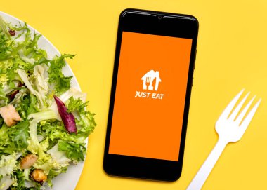 Sadece siyah ekranda marul salatası tabağı ve sarı zemin üzerinde beyaz plastik çatal olan akıllı telefonun uygulama simgesini ye.