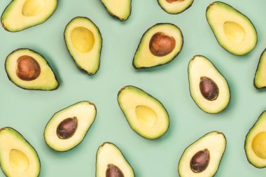 Yeşil arkaplanda taze avokado deseni var.