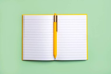 Fotokopi alanı ve yeşil arka planda sarı kalemli günlük aç. Çalışma masası