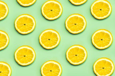 Pastel yeşil arka planda limon diliminden yapılmış yaratıcı desen