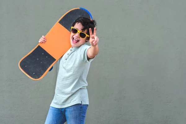 Bambino Felice Sorridente Con Skateboard Occhiali Sole Strada Sfondo Verde — Foto Stock