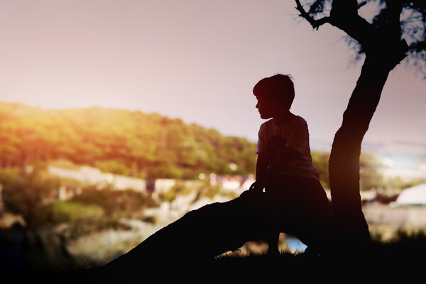 lonely boy next to a tree