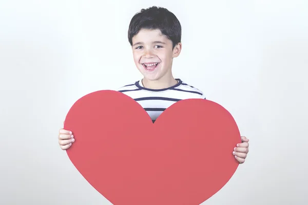 Niño sonriente con un corazón rojo para el Día de la Madre —  Fotos de Stock