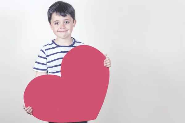 Usměvavý chlapec s červeným srdcem pro den matek — Stock fotografie