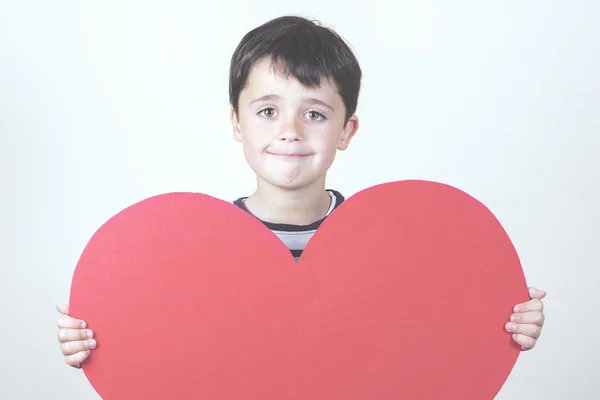 Niño sonriente con un corazón rojo para el Día de la Madre —  Fotos de Stock