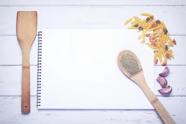 Bok med recept med ingredienser på ett bord — Stockfoto