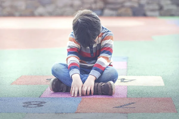 Smutny chłopiec siedzi na podłodze — Zdjęcie stockowe