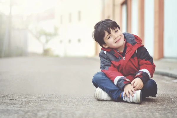Lycklig pojke sitter på golvet — Stockfoto