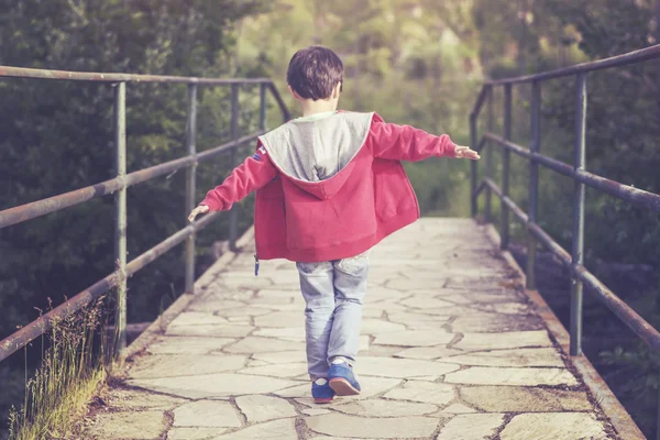 Lycklig pojke går på en bro — Stockfoto