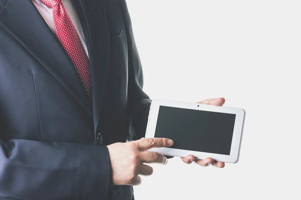 Empresario en traje y corbata usando una tableta — Foto de Stock