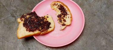 Tabağa serpilmiş çikolata parçacıkları serpiştirilmiş beyaz ekmek dilimleri