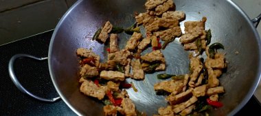 Otantik Endonezya usulü, yeşil biberli kızarmış tempeh, tatlı soya sosu ve tavada baharat..