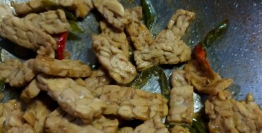 Otantik Endonezya usulü, yeşil biberli kızarmış tempeh, tatlı soya sosu ve tavada baharat..