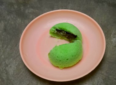 Yeşil pandan buğulanmış ekmek, dilimlenmiş çikolata dolgusu, pembe bir tabakta servis ediliyor. Geleneksel Endonezya tatlısı..