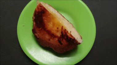 Küçük yeşil bir tabakta tatlı reçelli bir dilim ekmek, kahvaltı ya da tatlı için mükemmel..