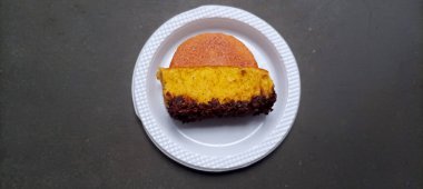 Beyaz tabağa çikolata parçacıkları serpiştirilmiş ev yapımı Endonezya Pukis kek diliminin yakın plan görüntüsü. Geleneksel tatlı atıştırmalık.