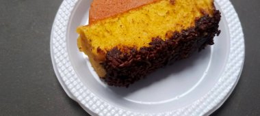 Beyaz tabağa çikolata parçacıkları serpiştirilmiş ev yapımı Endonezya Pukis kek diliminin yakın plan görüntüsü. Geleneksel tatlı atıştırmalık.