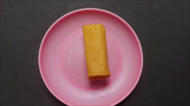 Muz aromalı gevrek ve geleneksel Endonezya ekmeği, pembe bir tabakta servis edilir..