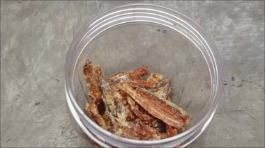 Beyaz bir kavanozda servis edilen lezzetli kızarmış ançüezler aperatif olarak kullanılır..