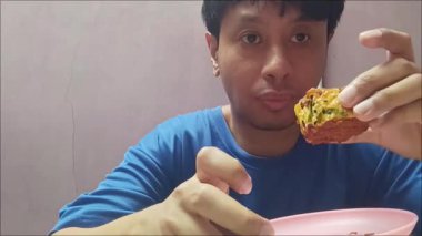 Bir adam lezzetli ev yapımı kıymalı ekmek yer. Asya 'da popüler tatlı ve lezzetli bir hamur işi..