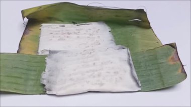 Tempeh 'in görüntüsü, çiğ mayalanmış soya fasulyesinden yapılmış, muz yapraklarına sarılmış sağlıklı bir bitki bazlı protein..