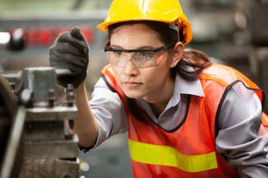 Kadın Mühendisler fabrikada bir cnc makinesi çalıştırıyor.