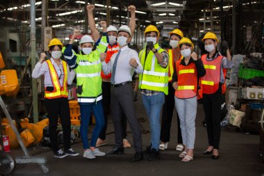 Mühendis ve Fabrika İşçi Takımı üretim hattına karşı duruyor. Erkek Endüstriyel Mühendisler Fabrika İşçisiyle konuşuyor. Ağır Sanayi Üretim Tesisinde çalışıyorlar..