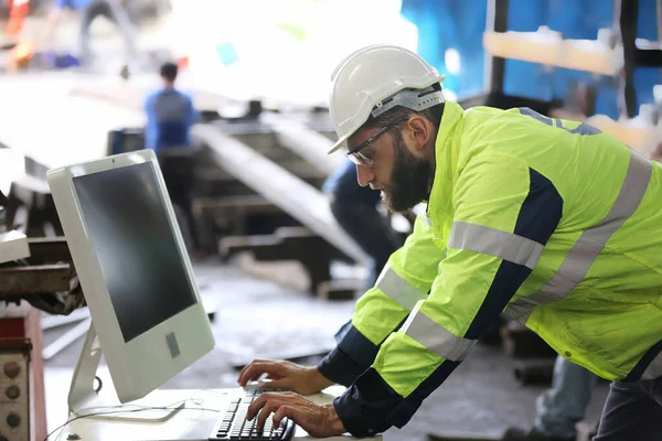 construction worker using laptop, Engineer standing with confident against machine environment in factory