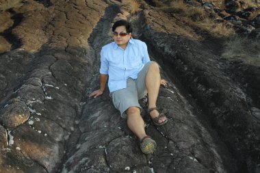 Taşın üzerinde oturan adam